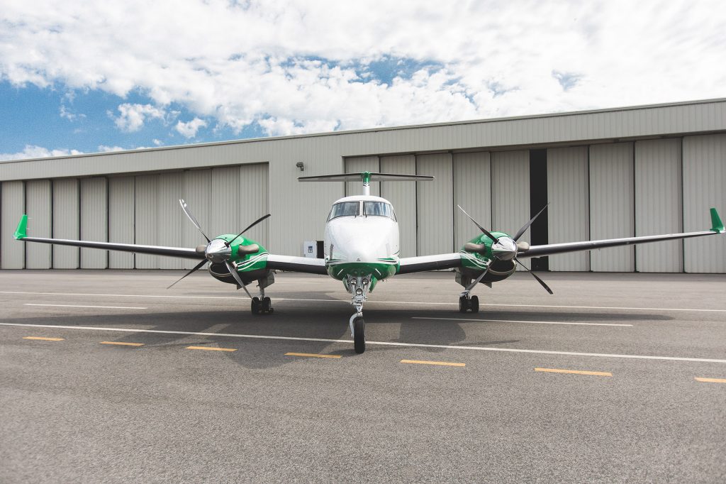 King Air 250 N716WL – Head-On Hangar View,Front-facing view of King Air 250 N716WL on tarmac with hangar doors in the background.