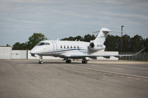 Bombardier Challenger 350 N777NE viewed from the rear side angle highlighting engine placement, tail structure, and aerodynamic styling.