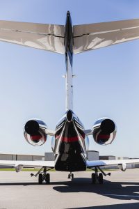 Vertical rear view of Bombardier Challenger 300 with tail number N300WK, showcasing twin jet engines and tail assembly at Raleigh-Durham International Airport, part of Flight Group Corporation’s private jet charter and aircraft management fleet.