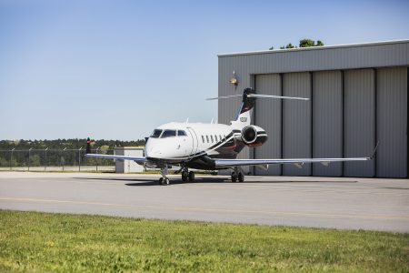 Bombardier Challenger 300 N300WK positioned near a hangar facility displaying its sleek exterior profile and executive aviation styling.